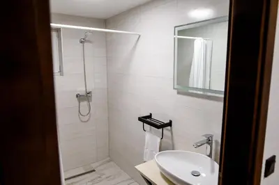 a white bathroom with a shower and a sink at Strane in Tomislavgrad