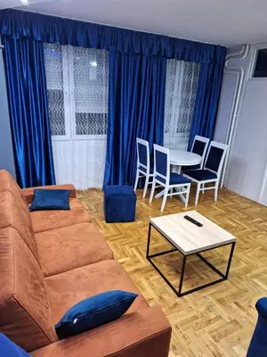a living room with a couch and a table and chairs at centar apartment in Banja Luka