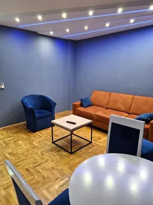 a living room with a couch and a table and chairs at centar apartment in Banja Luka