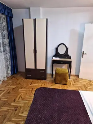 a bedroom with a dresser and a mirror and a table at centar apartment in Banja Luka