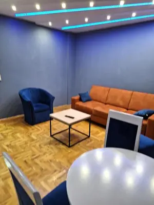 a living room with a couch and a table and chairs at centar apartment in Banja Luka