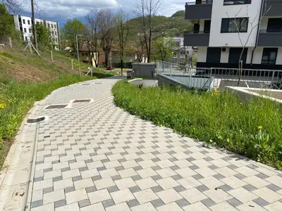 a cobblestone path in a city with a building at Zeus apartman in Hiseti