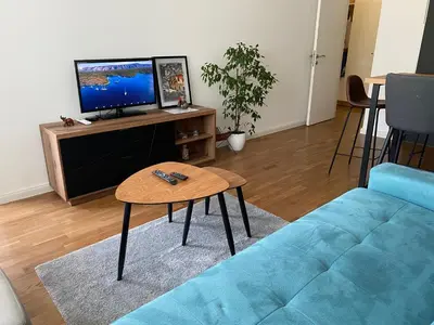 a living room with a blue couch and a table at Zeus apartman in Hiseti