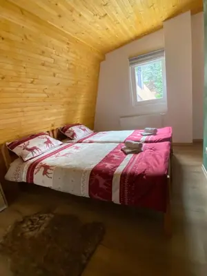 a bedroom with a bed in a wooden room at Apartmani Snježna Kraljica Vlašić 1 in Vlasic