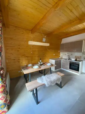 a kitchen with a table and a wooden ceiling at Apartmani Snježna Kraljica Vlašić 1 in Vlasic