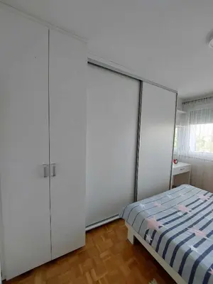 a bedroom with white cabinets and a bed at Apartman OMANOVIĆ in Bihać