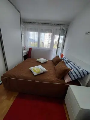 a bedroom with a large bed with two towels on it at Apartman OMANOVIĆ in Bihać