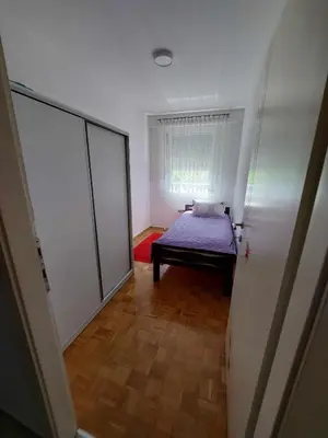 a small room with a bed and a window at Apartman OMANOVIĆ in Bihać