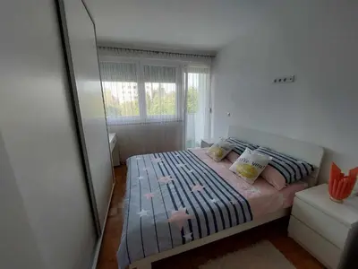 a bedroom with a bed with a large mirror at Apartman OMANOVIĆ in Bihać