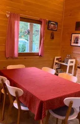 a dining room with a red table and chairs at Wood Cabin Hillside Retreat in Banja Luka