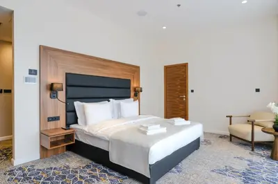 a bedroom with a large bed and a chair at Hotel Vema in Visoko