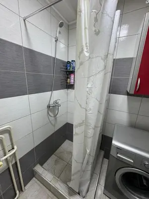 a shower in a bathroom with a washing machine at Stan na dan Hasanovic in Tuzla