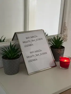 a sign sitting on a table with three plants at Stan na dan Hasanovic in Tuzla