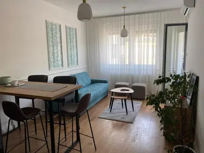 a living room with a blue couch and a table at Zeus in Hiseti
