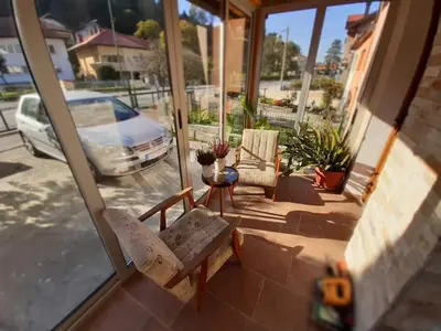 a porch with two chairs and a table and a car at Restart Apartment in Visoko