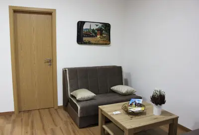 a living room with a couch and a table at Restart Apartment in Visoko