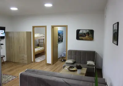 a living room with a couch and a table at Restart Apartment in Visoko