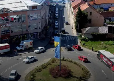 a city street with cars parked on the road at Apartman Skver Tuzla in Tuzla