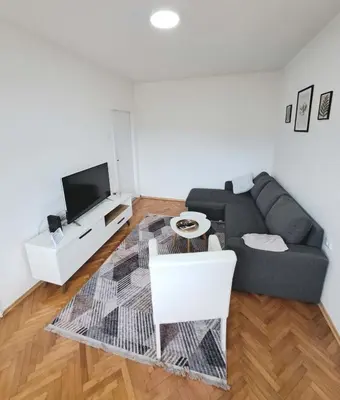 a living room with a couch and a tv at Apartman Skver Tuzla in Tuzla