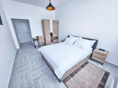 a bedroom with a large white bed and a table at Hotel Balon in Velika Kladuša