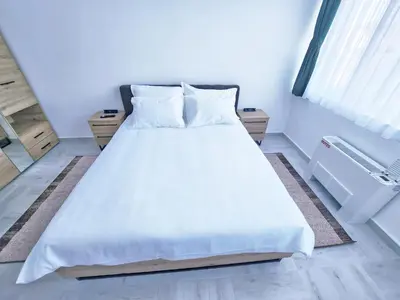 a bedroom with a large bed with white sheets and pillows at Hotel Balon in Velika Kladuša