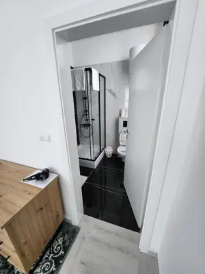 a bathroom with a walk in shower and a mirror at Hotel Balon in Velika Kladuša