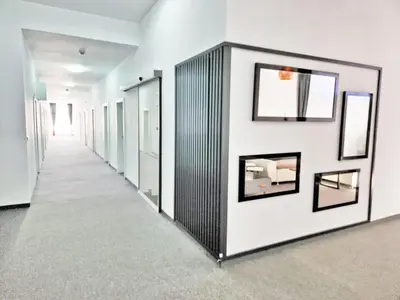 a corridor in a building with white walls and mirrors at Hotel Balon in Velika Kladuša