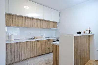 a kitchen with wooden cabinets and white appliances at Lux Sara Apartments in Visoko