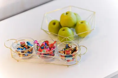 a glass bowl filled with toys next to a basket of apples at Lux Sara Apartments in Visoko