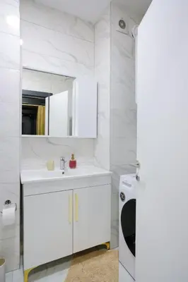 a white bathroom with a sink and a mirror at Lux Sara Apartments in Visoko