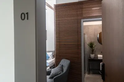 a living room with two chairs and a bedroom at LANTerna Boutique Hotel in Srbac
