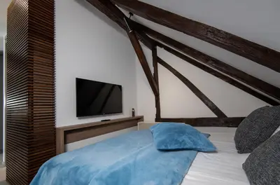 a bedroom with a bed with a tv on the wall at LANTerna Boutique Hotel in Srbac