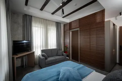 a bedroom with a bed and a chair and a television at LANTerna Boutique Hotel in Srbac