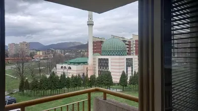 a view from a balcony of a building with a mosque at Stan u Zenici in Zenica