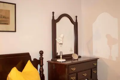 a lamp on a dresser next to a mirror at Stan u Zenici in Zenica