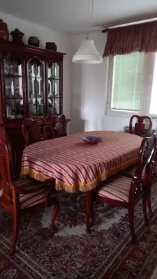 a dining room with a table and chairs and a window at Stan u Zenici in Zenica