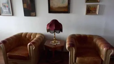two leatherchairs and a table with a lamp in a room at Stan u Zenici in Zenica