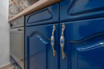 a blue kitchen cabinet with tongs on it at Calendula apartments in Tuzla