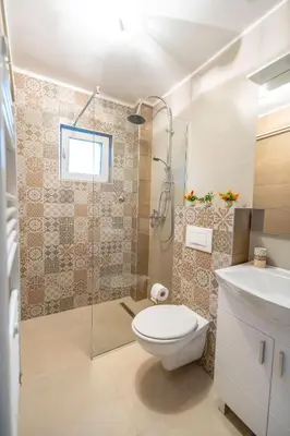 a bathroom with a toilet and a shower and a sink at Calendula apartments in Tuzla