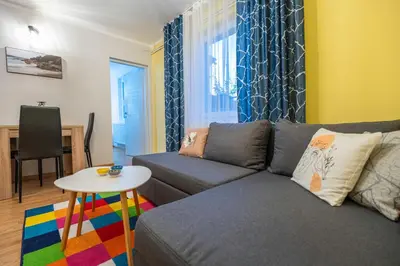 a living room with a couch and a table at Calendula apartments in Tuzla