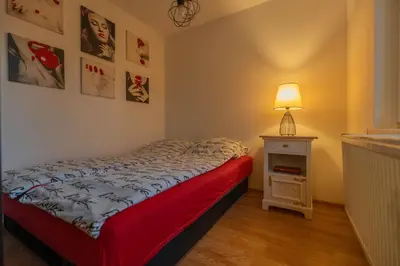 a small bedroom with a bed and a lamp at Calendula apartments in Tuzla