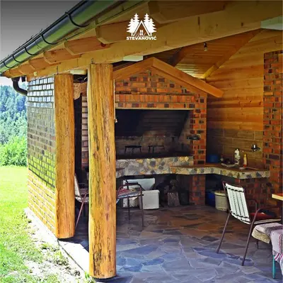 a patio with a fireplace in a log cabin at Vikendica Stevanovic in Doboj