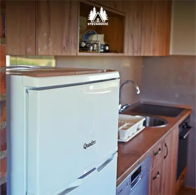 a kitchen with a white refrigerator and a sink at Vikendica Stevanovic in Doboj