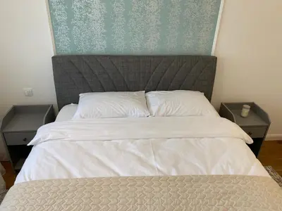 a bedroom with a large bed with two night stands at Zeus apartman in Banja Luka