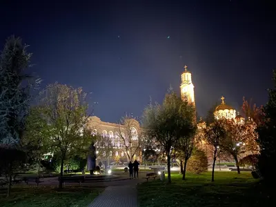 a large building with a clock tower at night at Zeus apartman in Banja Luka