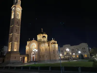 a large building with a clock tower at night at Zeus apartman in Banja Luka