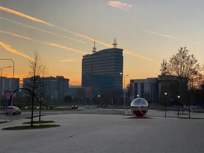 a parking lot with a large building in the city at Zeus apartman in Banja Luka