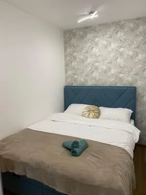 a bedroom with a bed with a blue headboard at Apartment Romano Banja Luka in Banja Luka