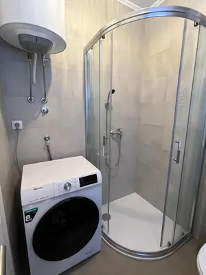 a shower with a washing machine in a bathroom at Apartment Romano Banja Luka in Banja Luka