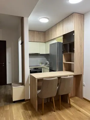a kitchen with a wooden table and two chairs at Apartment Romano Banja Luka in Banja Luka